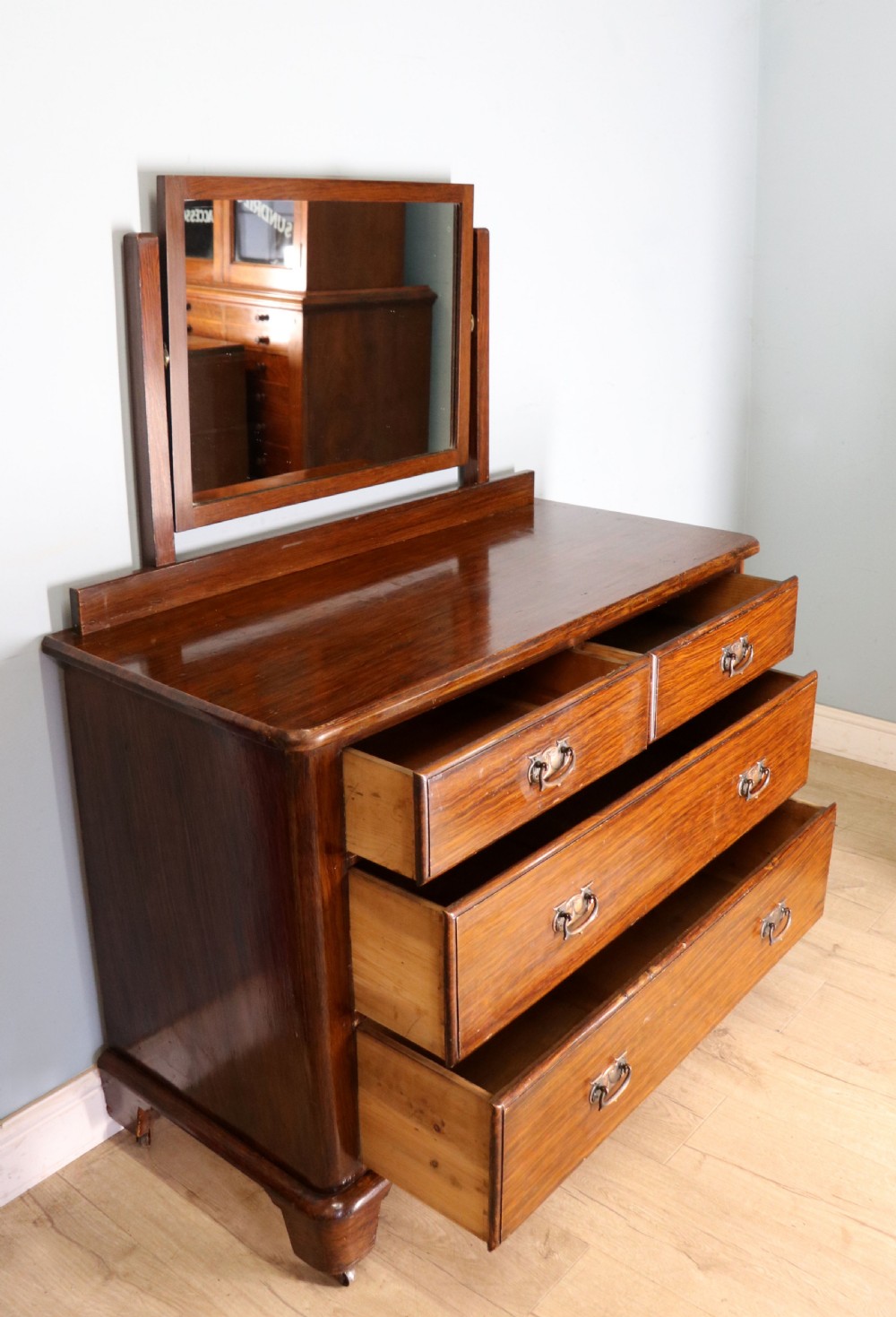 A dark mahogany Victorian dressing chest featuring a rectangular pivoting top mirror and four drawers with metal drop handles. View IV