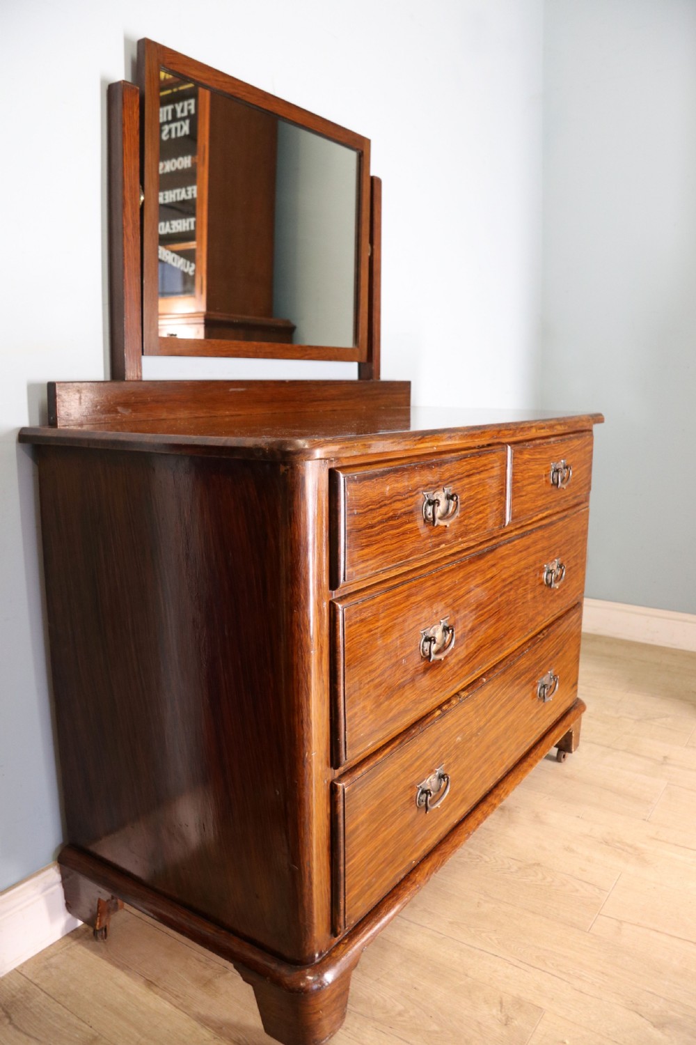 A dark mahogany Victorian dressing chest featuring a rectangular pivoting top mirror and four drawers with metal drop handles. View V