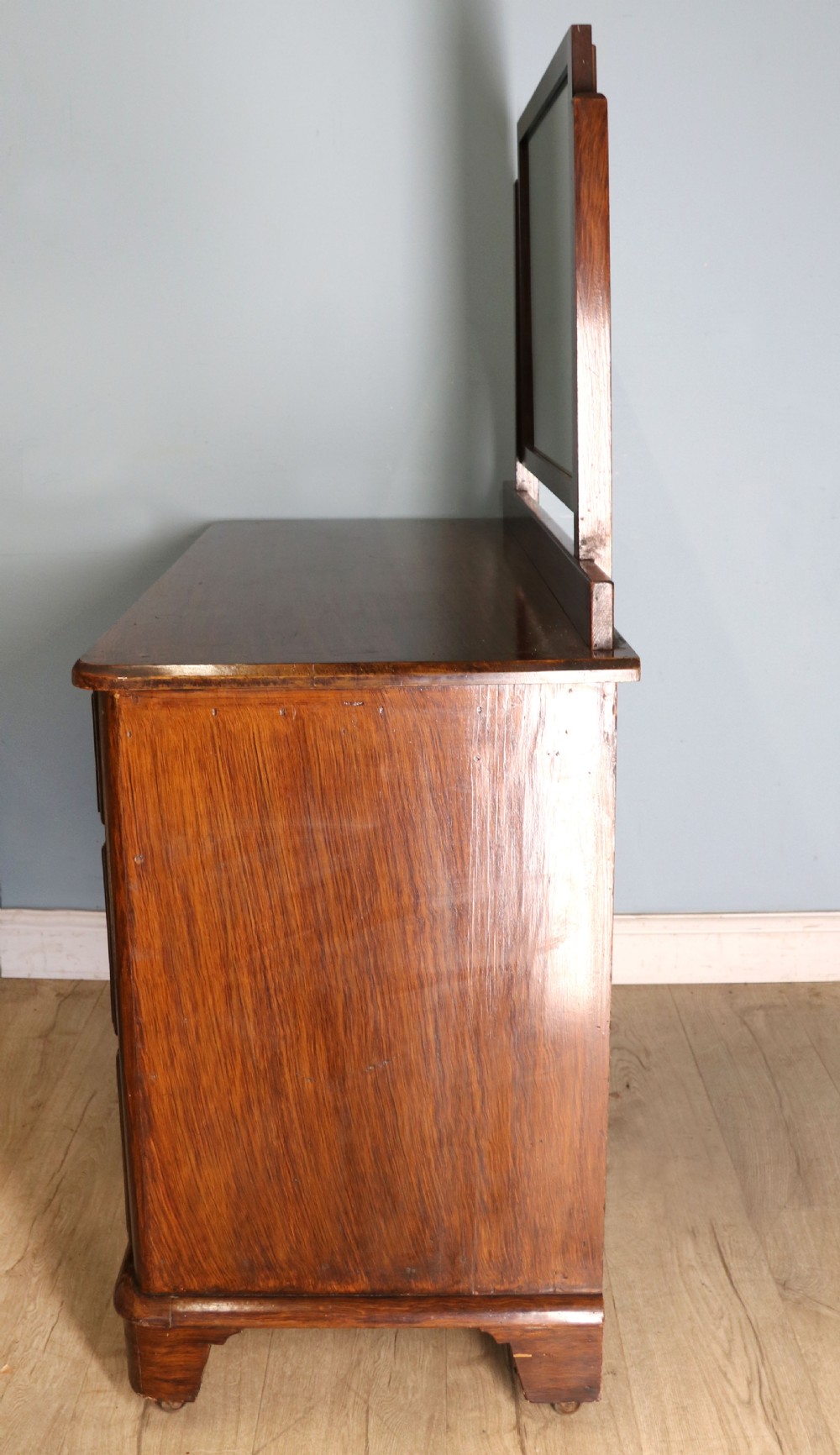 A dark mahogany Victorian dressing chest featuring a rectangular pivoting top mirror and four drawers with metal drop handles. View VI