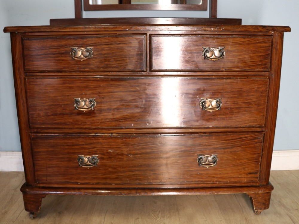 A dark mahogany Victorian dressing chest featuring a rectangular pivoting top mirror and four drawers with metal drop handles. View X