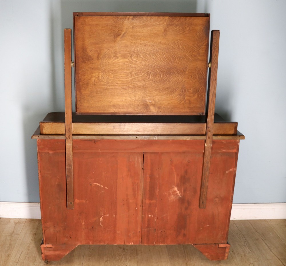 A dark mahogany Victorian dressing chest featuring a rectangular pivoting top mirror and four drawers with metal drop handles. View XVIII