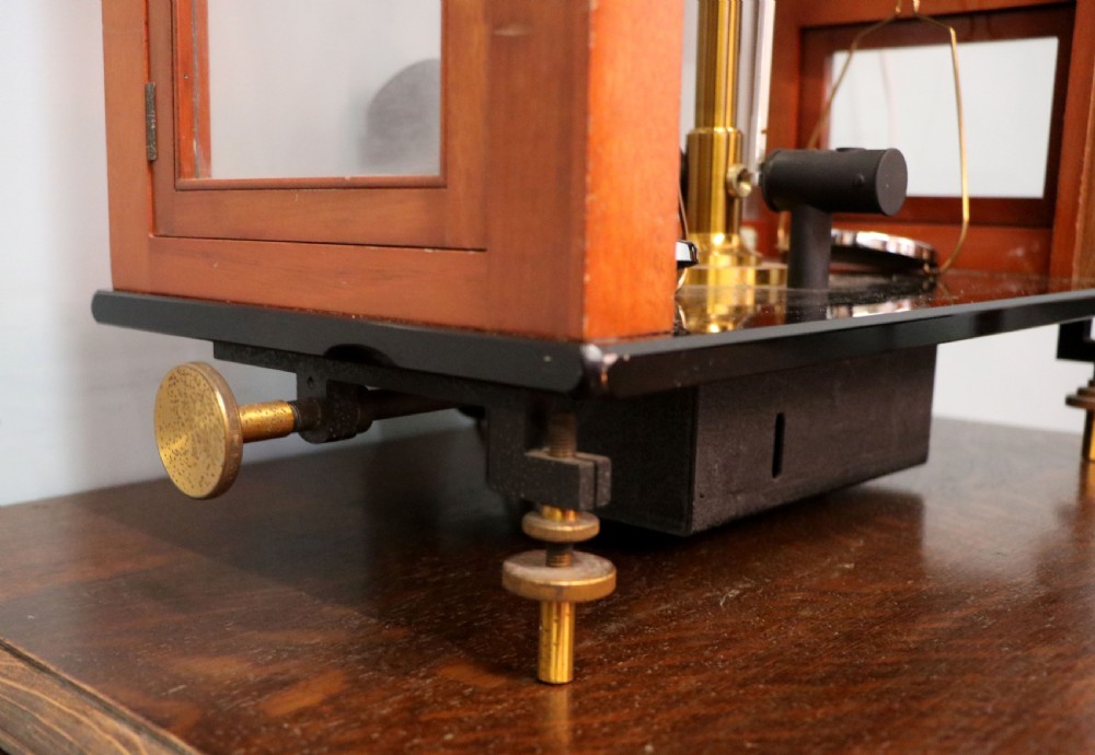 An Oertling precision chemists beam balance scale with a brass mechanism housed inside a glazed timber cabinet featuring gilded gold typography. View XVI