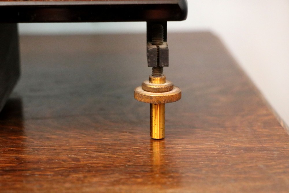 An Oertling precision chemists beam balance scale with a brass mechanism housed inside a glazed timber cabinet featuring gilded gold typography. View XVII