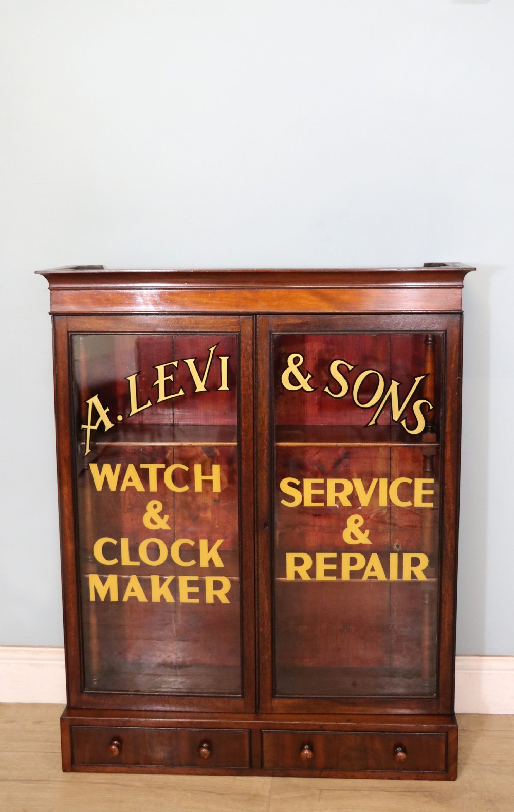A quality mahogany shop display cabinet, later sign written for A.Levi  watch and clockmakers.