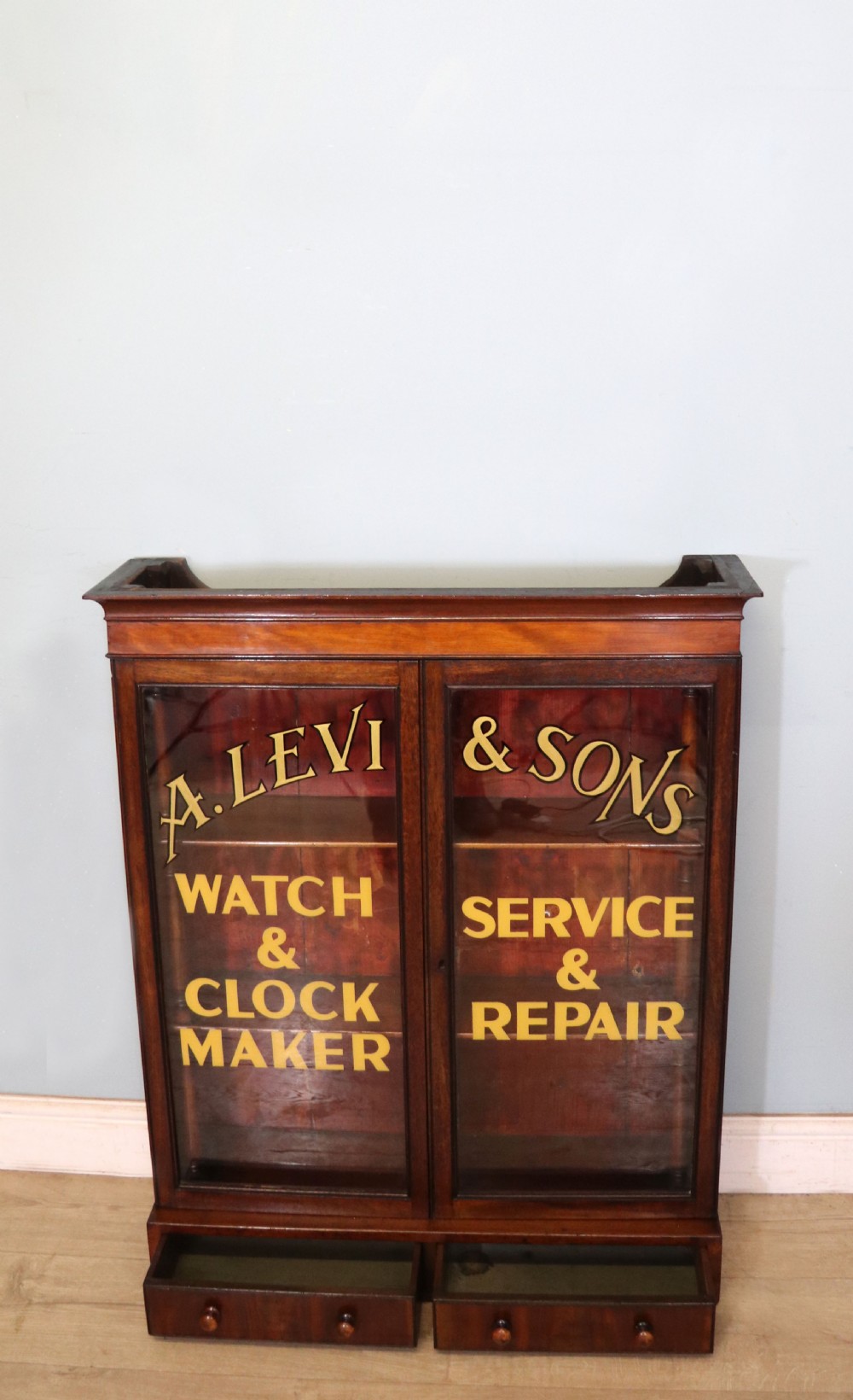 A quality mahogany shop display cabinet, later sign written for A.Levi  watch and clockmakers. View VIII
