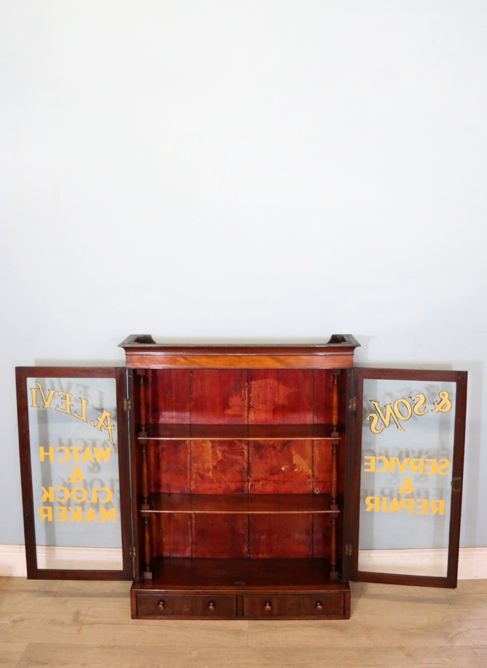 A quality mahogany shop display cabinet, later sign written for A.Levi  watch and clockmakers. View XI