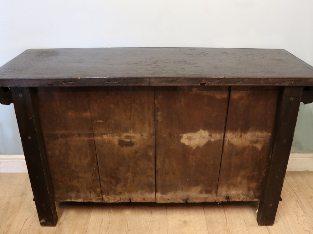 A dark carved Flemish oak side cabinet featuring detailed figural caryatids, relief mascarons, architectural door panels, and heavy bun feet. View XX