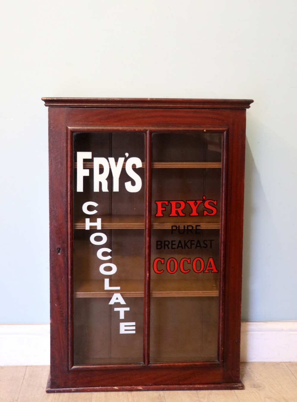 A 19th century mahogany shop display cabinet later sign written for Fry’s cocoa.