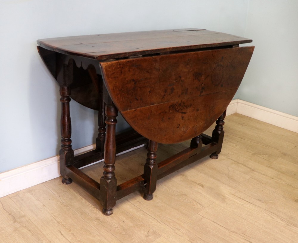 A lovely 18th century English oak drop leaf dining table. View IV