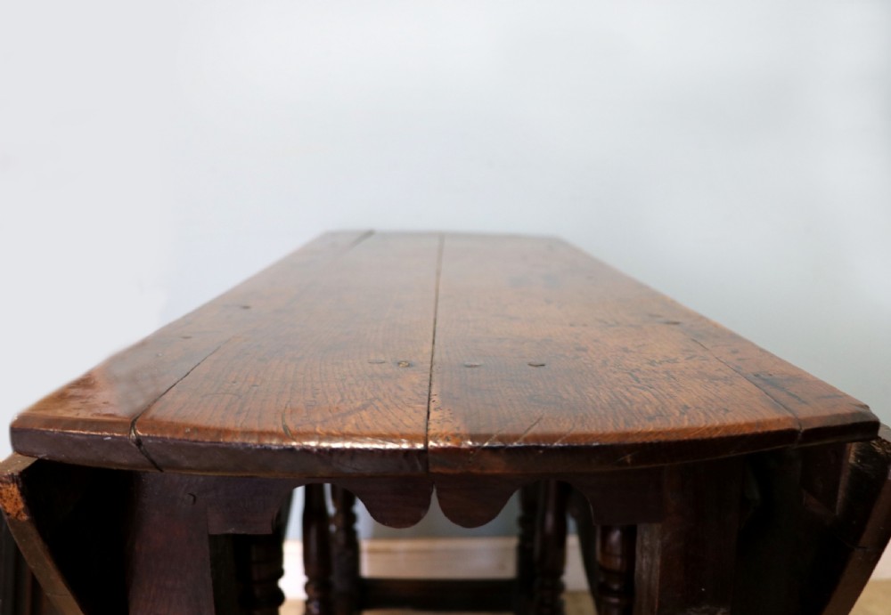 A lovely 18th century English oak drop leaf dining table. View IX