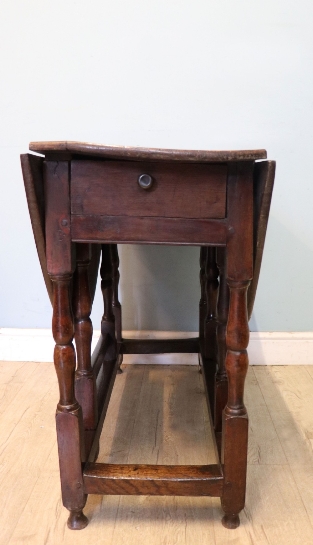 A lovely 18th century English oak drop leaf dining table.  View XI