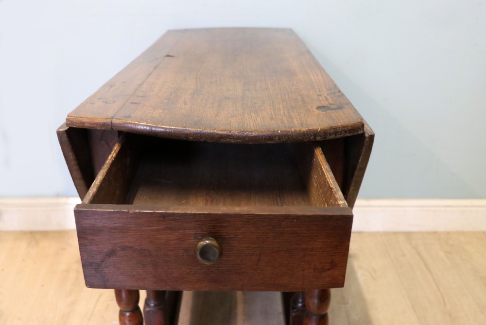 A lovely 18th century English oak drop leaf dining table.  View XVII