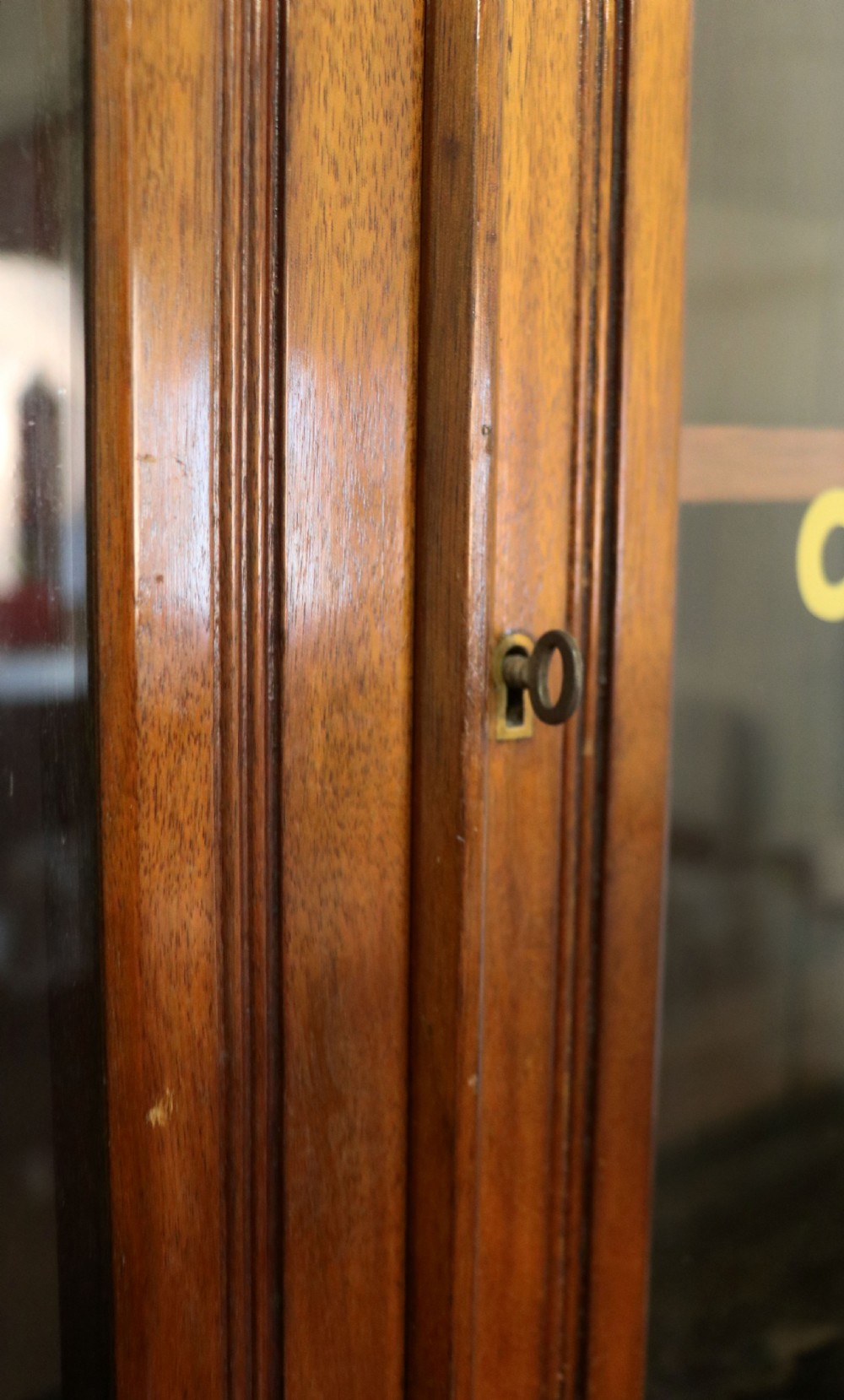 A late 19th-century walnut glazed display cabinet featuring two glass doors decorated with gilded signwriting above two drawers and a panelled base cupboard. View VIII