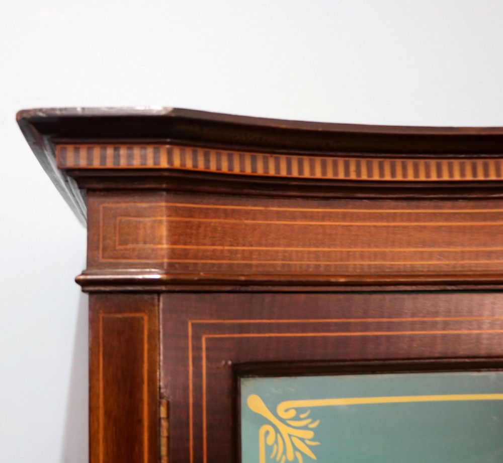 An Edwardian mahogany display cabinet featuring double glazed doors with gold sign-written perfume brand names against a turquoise painted interior. View IX
