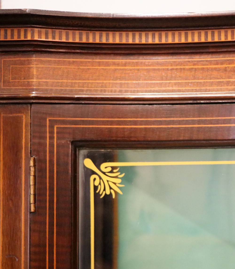 An Edwardian mahogany display cabinet featuring double glazed doors with gold sign-written perfume brand names against a turquoise painted interior. View X