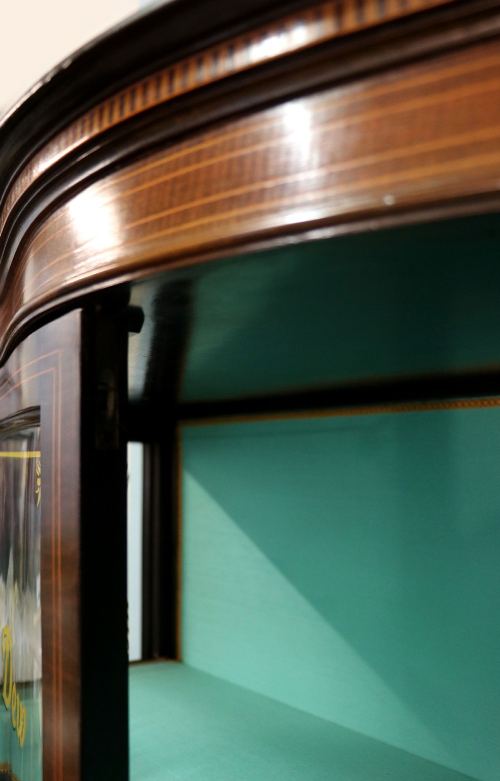 An Edwardian mahogany display cabinet featuring double glazed doors with gold sign-written perfume brand names against a turquoise painted interior. View XII