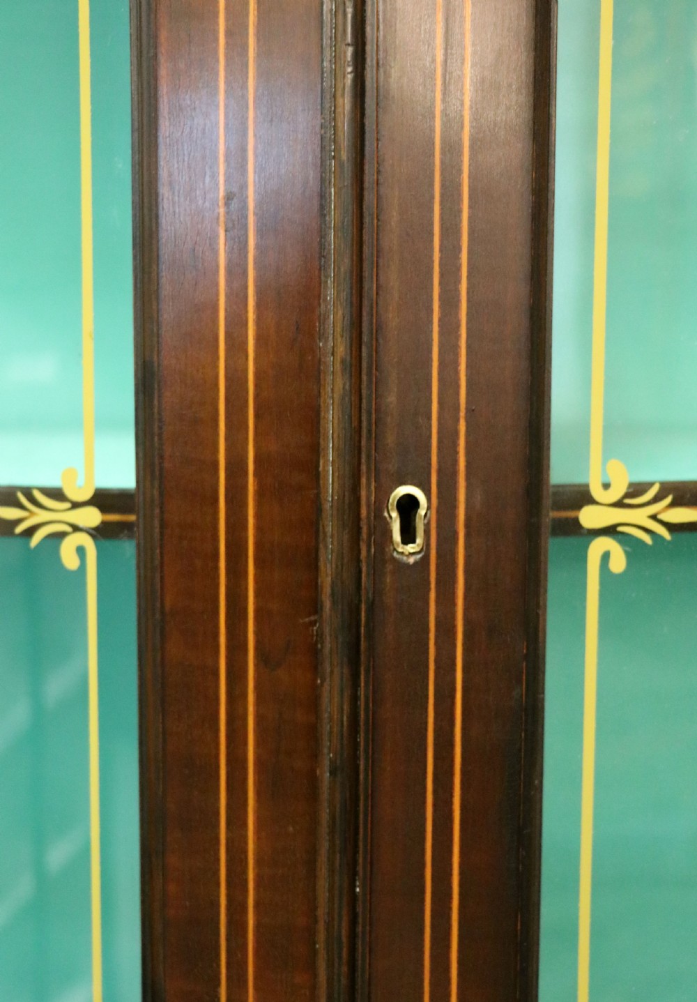 An Edwardian mahogany display cabinet featuring double glazed doors with gold sign-written perfume brand names against a turquoise painted interior. View XXI