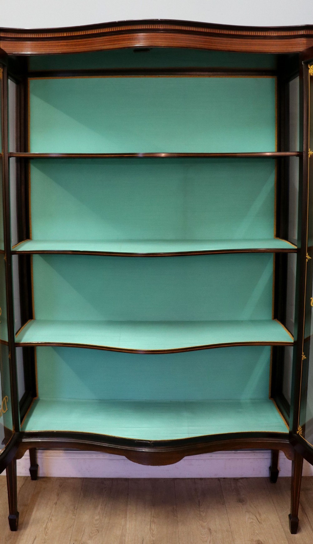 An Edwardian mahogany display cabinet featuring double glazed doors with gold sign-written perfume brand names against a turquoise painted interior. View XXIII