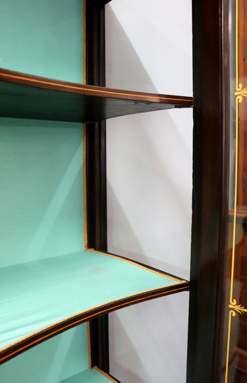 An Edwardian mahogany display cabinet featuring double glazed doors with gold sign-written perfume brand names against a turquoise painted interior. View XXIV