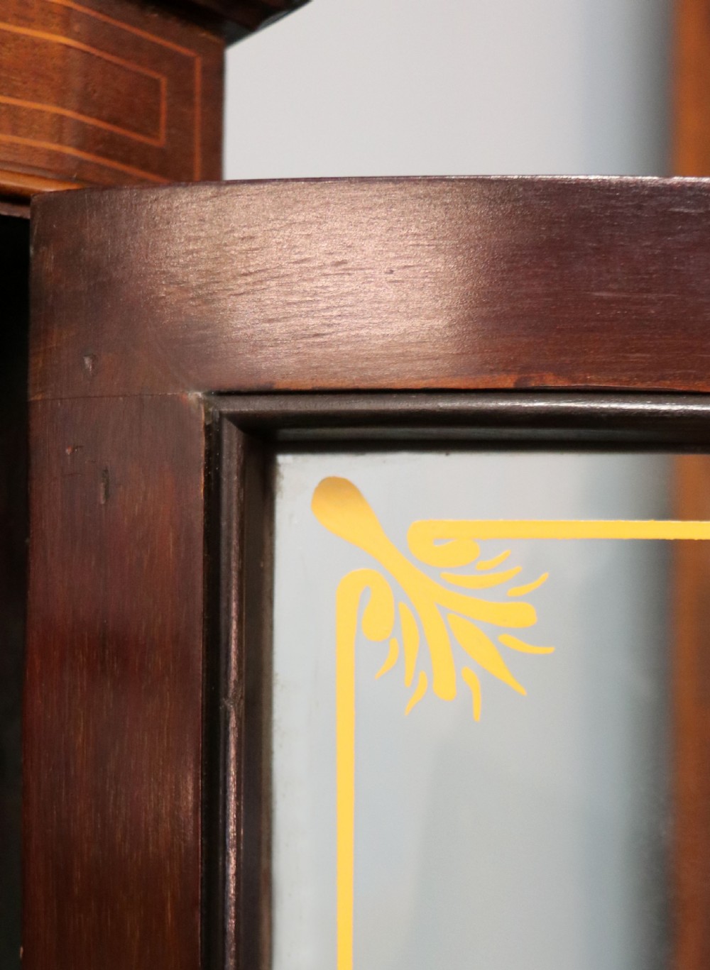 An Edwardian mahogany display cabinet featuring double glazed doors with gold sign-written perfume brand names against a turquoise painted interior. View XXV