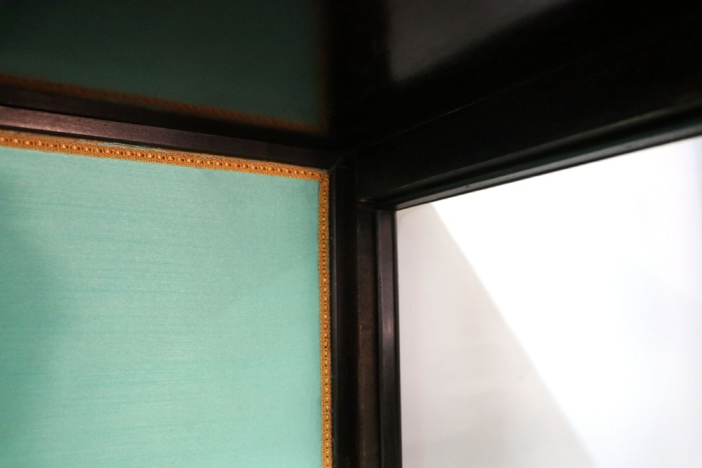 An Edwardian mahogany display cabinet featuring double glazed doors with gold sign-written perfume brand names against a turquoise painted interior. View XXVII