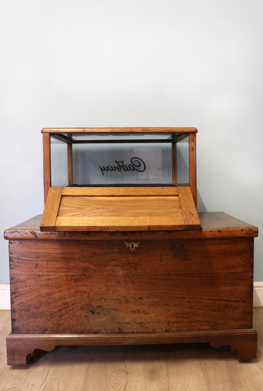 An early 20th-century oak countertop display cabinet featuring glazed panels and gold sign-written Cadburys Dairy Milk Chocolate lettering. View XIV