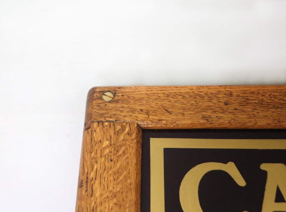 An early 20th-century oak countertop display cabinet featuring glazed panels and gold sign-written Cadburys Dairy Milk Chocolate lettering. View XIX