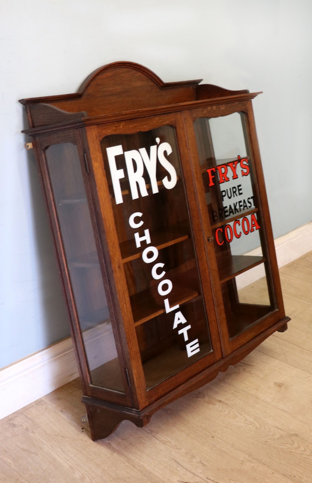  A wonderful Edwardian wall mounted solid oak framed display cabinet,  later sign written advertising Fry's Chocolate. View III