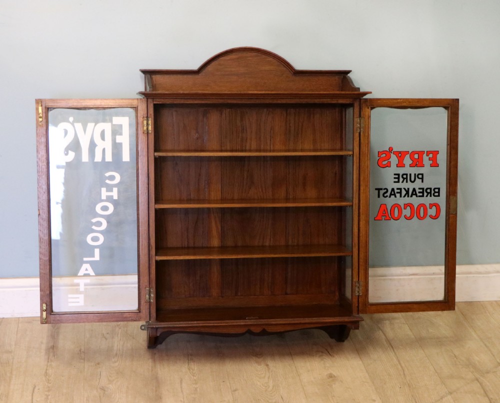  A wonderful Edwardian wall mounted solid oak framed display cabinet,  later sign written advertising Fry's Chocolate. View IV
