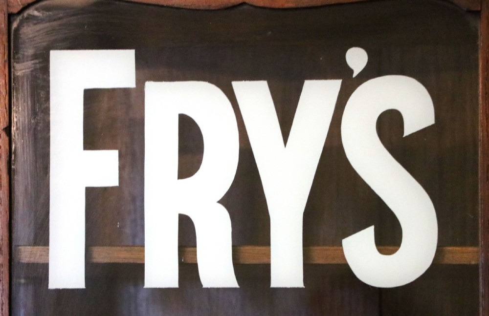  A wonderful Edwardian wall mounted solid oak framed display cabinet,  later sign written advertising Fry's Chocolate. View VIII