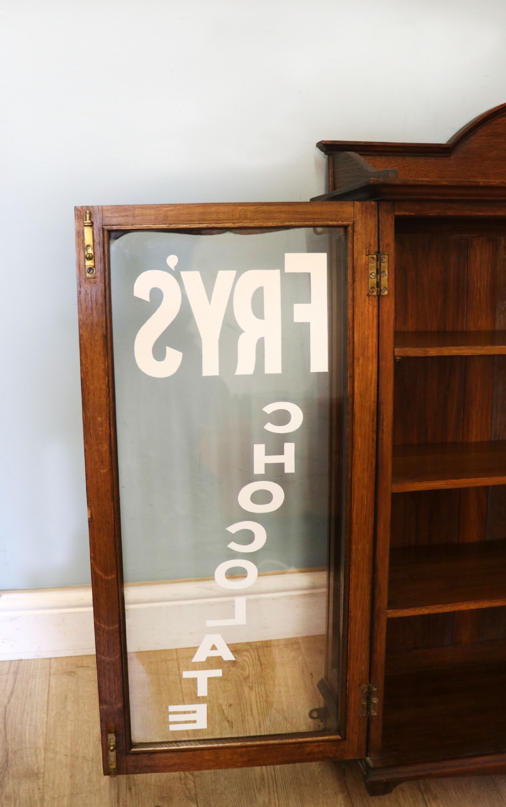  A wonderful Edwardian wall mounted solid oak framed display cabinet,  later sign written advertising Fry's Chocolate. View XIII