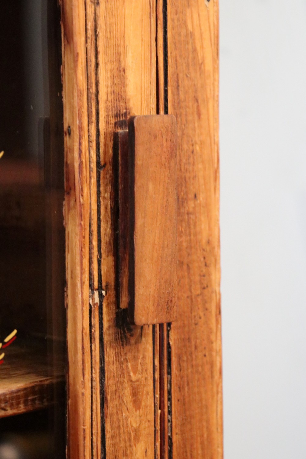 A glazed pine cabinet featuring a glass door with gold and red bakery signwriting and internal wooden shelves. View XV