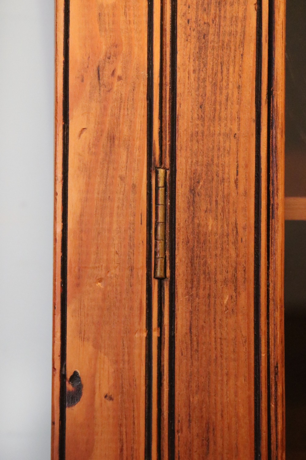 A glazed pine cabinet featuring a glass door with gold and red bakery signwriting and internal wooden shelves. View XVII