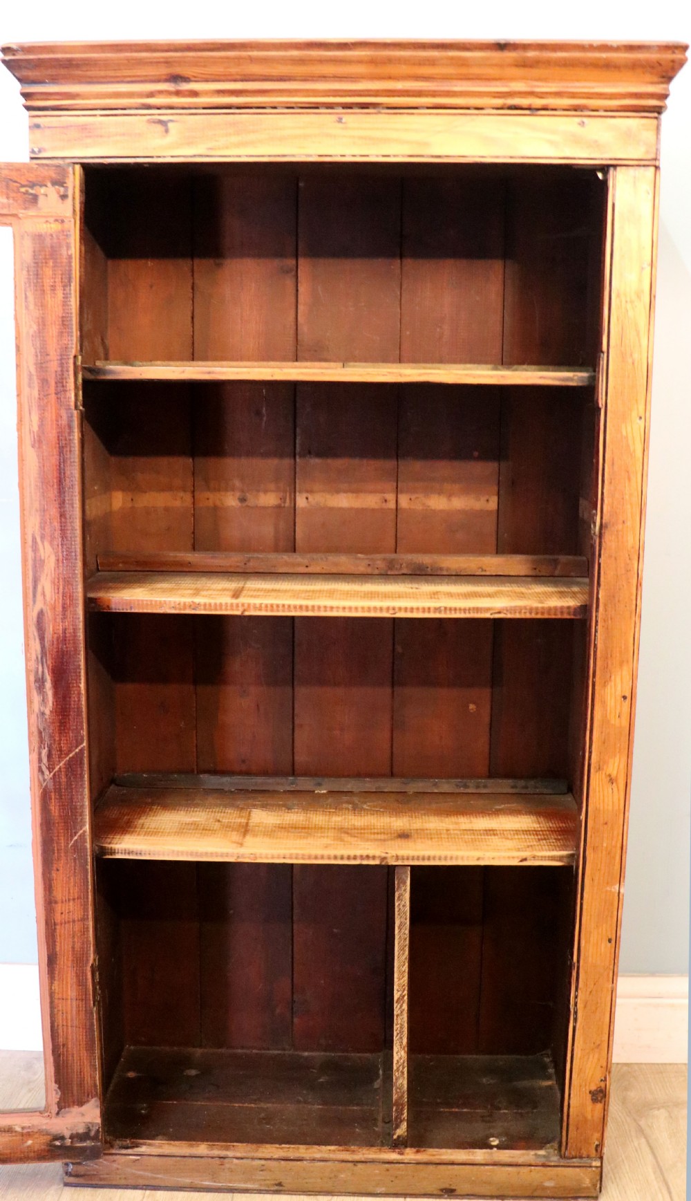 A glazed pine cabinet featuring a glass door with gold and red bakery signwriting and internal wooden shelves. View XVIII