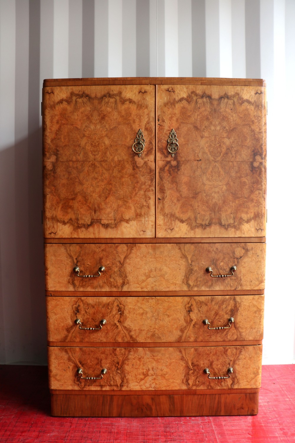 A 1930s burr walnut veneered tallboy cabinet.