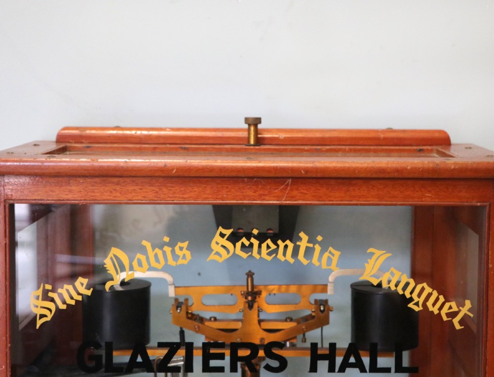 A set of brass chemist precision beam scales enclosed within a glazed mahogany display case featuring gilt and black sign-written lettering. View VIII