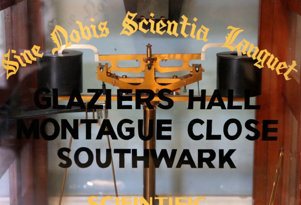 A set of brass chemist precision beam scales enclosed within a glazed mahogany display case featuring gilt and black sign-written lettering. View XII