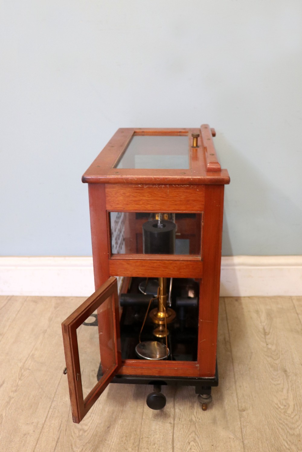 A set of brass chemist precision beam scales enclosed within a glazed mahogany display case featuring gilt and black sign-written lettering. View XIV