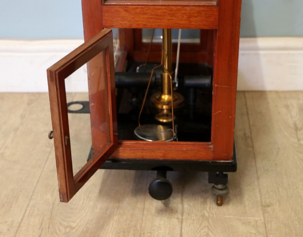 A set of brass chemist precision beam scales enclosed within a glazed mahogany display case featuring gilt and black sign-written lettering. View XVII