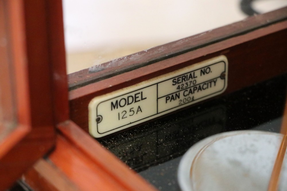 A set of brass chemist precision beam scales enclosed within a glazed mahogany display case featuring gilt and black sign-written lettering. View XVIII