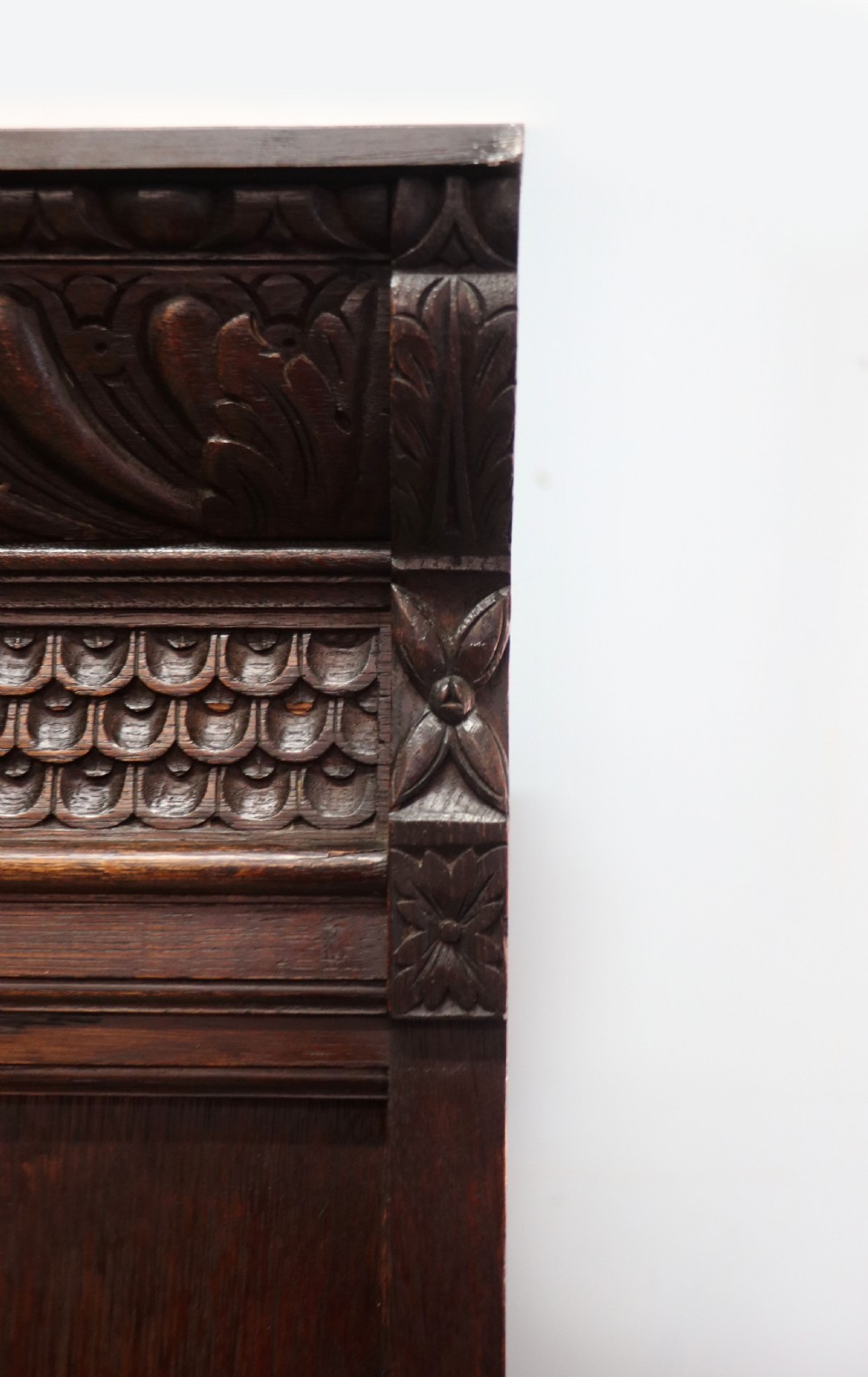 A late 19th-century dark oak glazed display cabinet on a tall stand featuring detailed lion mask relief carvings and hand-painted German heraldic emblems on the glass doors. View XIII
