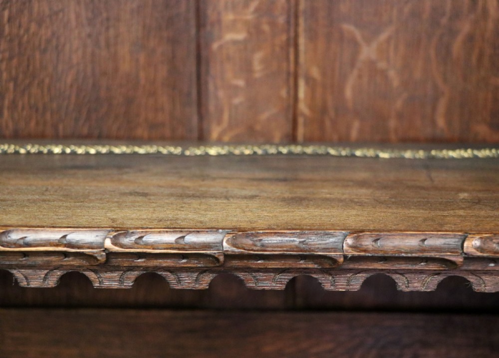 A late 19th-century dark oak glazed display cabinet on a tall stand featuring detailed lion mask relief carvings and hand-painted German heraldic emblems on the glass doors. View XXVIII