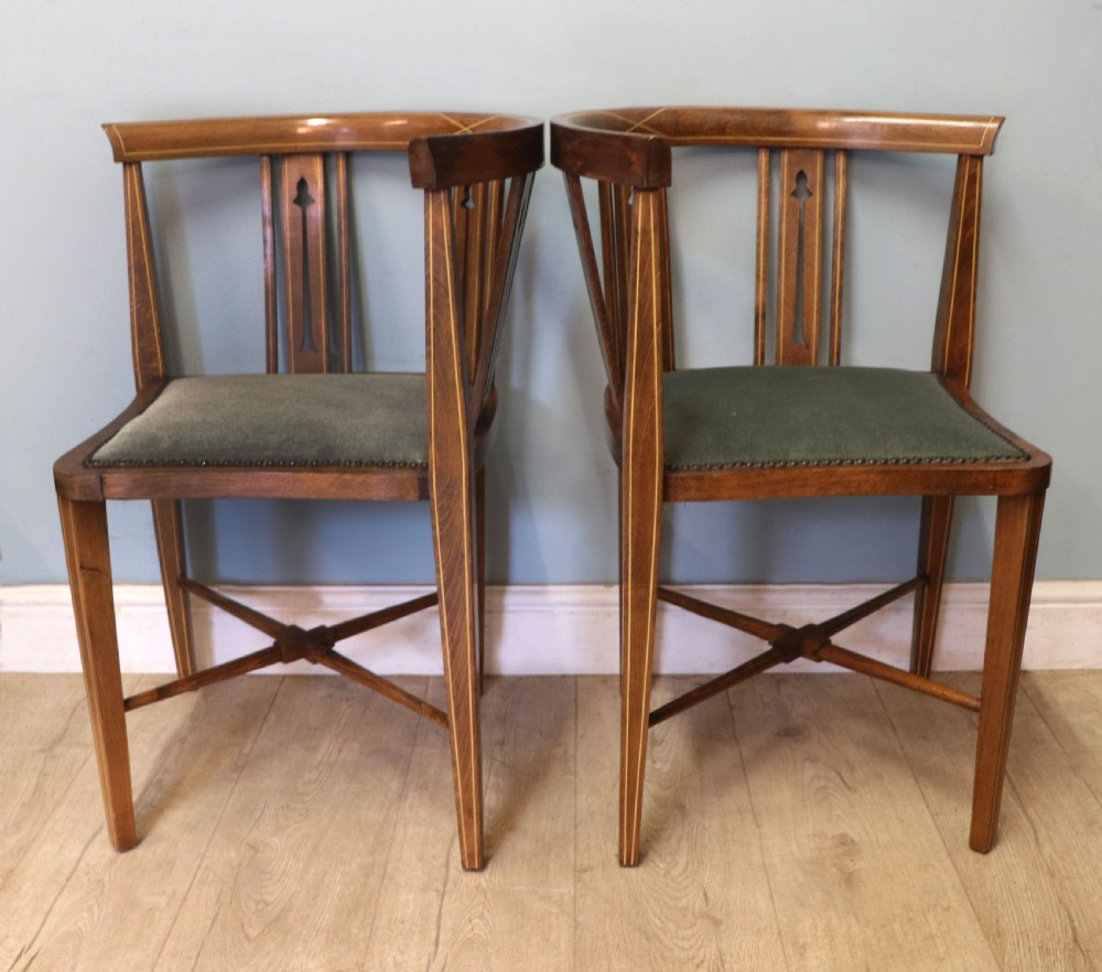 A pair of antique mahogany corner chairs featuring boxwood line inlay, pierced back splats, cross-braced legs, and green upholstered seats with stud trim. View V