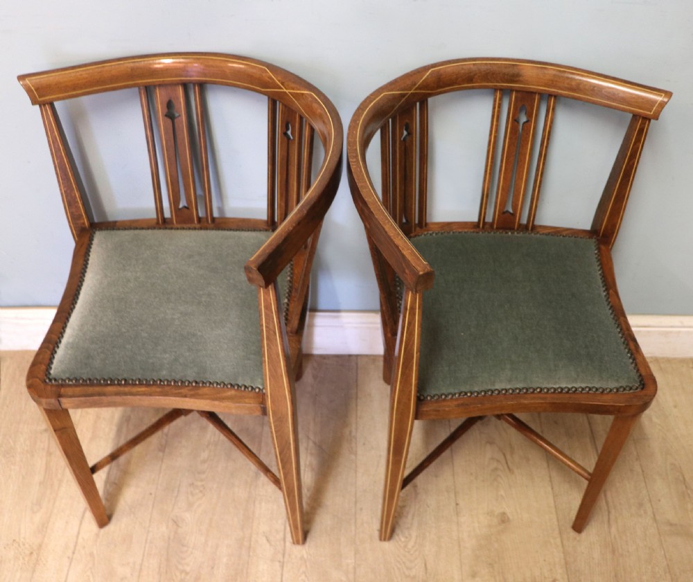 A pair of antique mahogany corner chairs featuring boxwood line inlay, pierced back splats, cross-braced legs, and green upholstered seats with stud trim. View VI