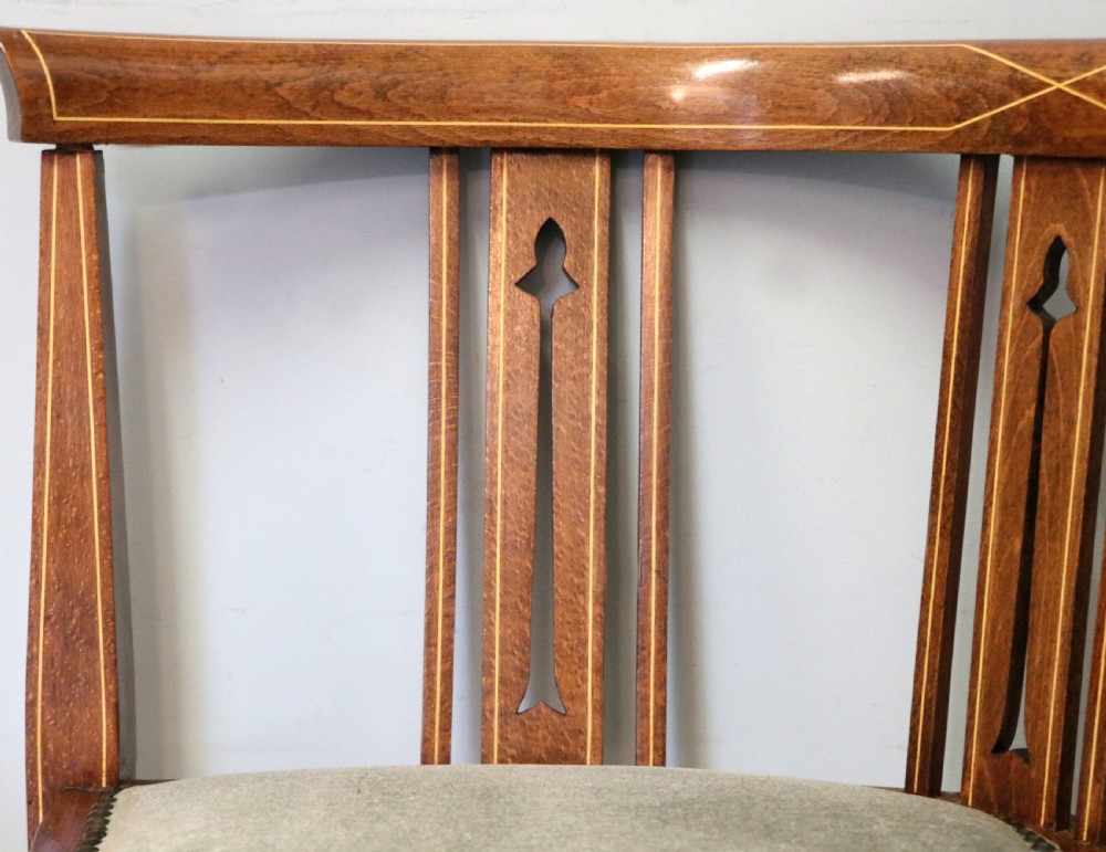 A pair of antique mahogany corner chairs featuring boxwood line inlay, pierced back splats, cross-braced legs, and green upholstered seats with stud trim. View XVI