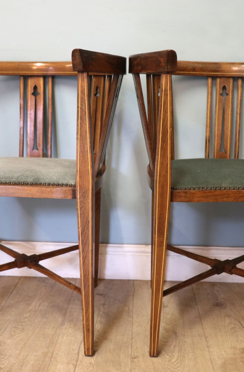 A pair of antique mahogany corner chairs featuring boxwood line inlay, pierced back splats, cross-braced legs, and green upholstered seats with stud trim. View XX