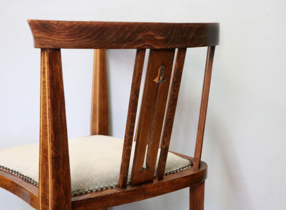 A pair of antique mahogany corner chairs featuring boxwood line inlay, pierced back splats, cross-braced legs, and green upholstered seats with stud trim. View XXVIII