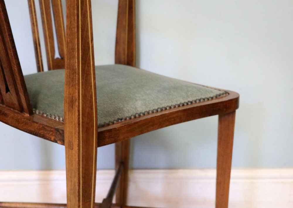A pair of antique mahogany corner chairs featuring boxwood line inlay, pierced back splats, cross-braced legs, and green upholstered seats with stud trim. View XXIX