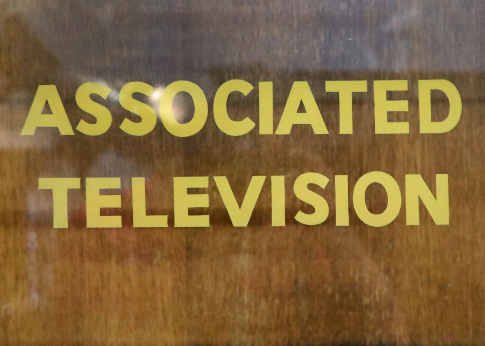  A 1930s/ 1940s oak bookcase or display cabinet decorated with the Associated Television logo. View V