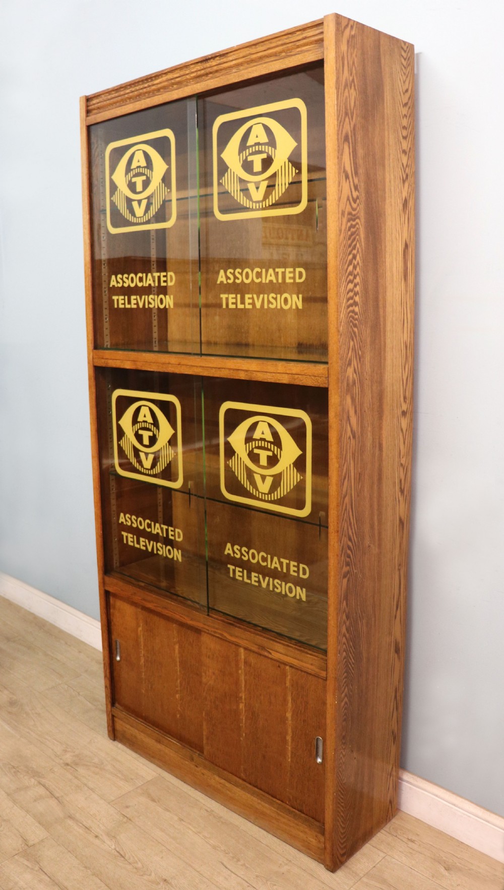  A 1930s/ 1940s oak bookcase or display cabinet decorated with the Associated Television logo. View VI